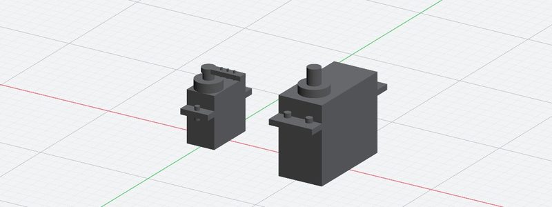Ein Micro-Servo SG90 und ein Standardservo FS5113R nebeneinander auf dem Raster, maßstäblich